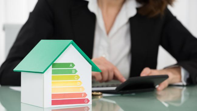 verweist auf: Informationen für Fachunternehmen und Energieeffizienz-Experten Rechnung mit Euro-Münzen und Energieeffizienzrate am Schreibtisch (verweist auf: Informationen für Fachunternehmen und Energieeffizienz-Experten)