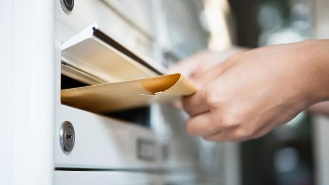 verweist auf: Beschwerde einreichen Nahaufnahme einer Hand, die einen Umschlag hält und in den Briefkasten einwirft. (verweist auf: Beschwerde einreichen)