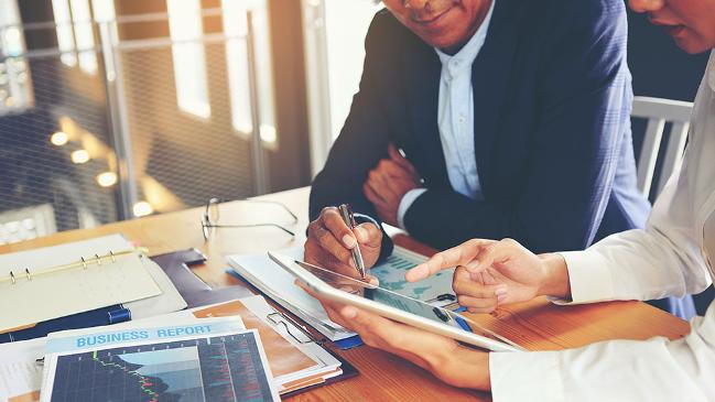 verweist auf: Unternehmensberatung Zwei Geschäftsleute beraten und planen Geschäftsabläufe. (verweist auf: Unternehmensberatung)